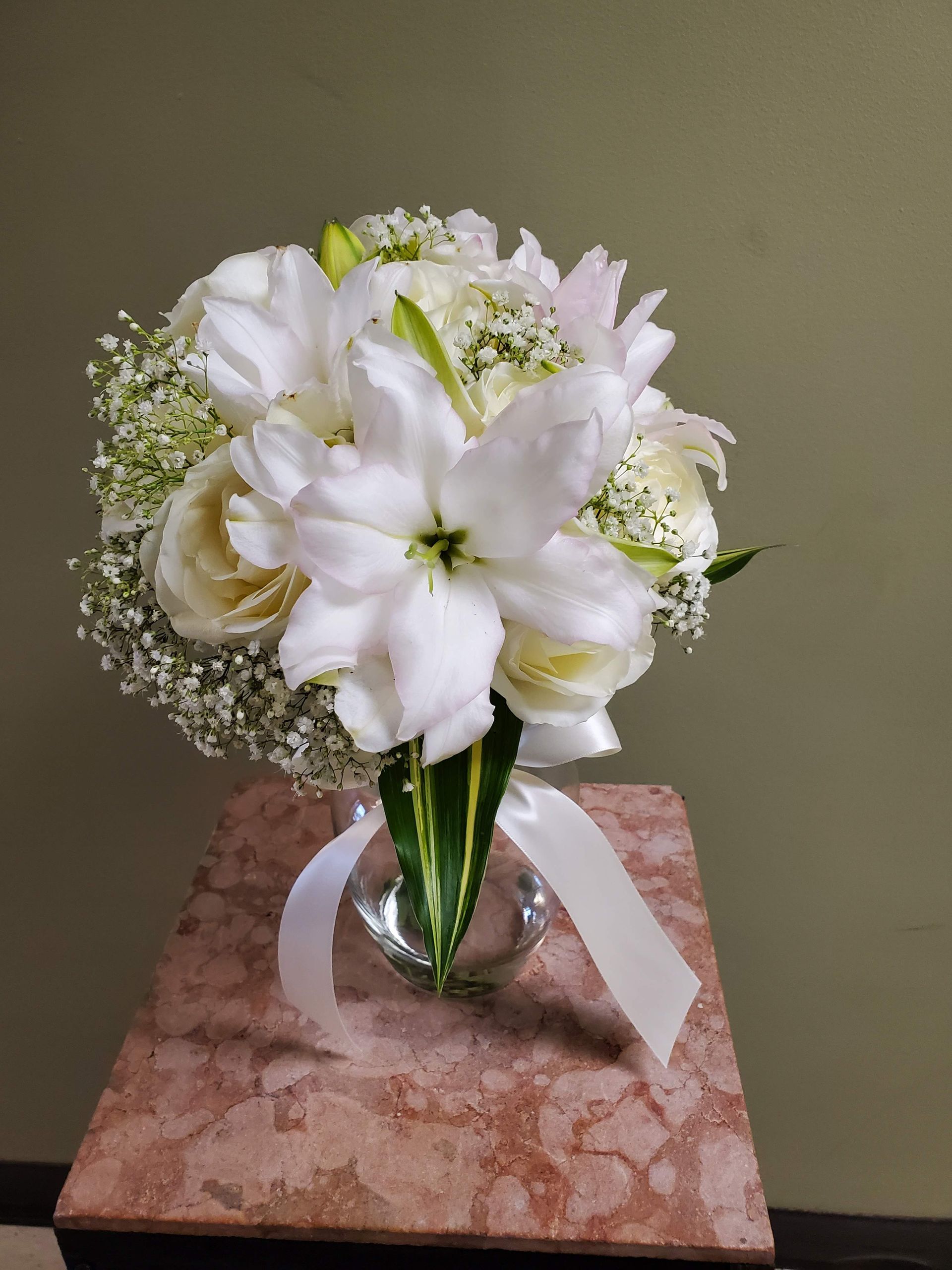 A bouquet of flowers is sitting on a wooden stool.