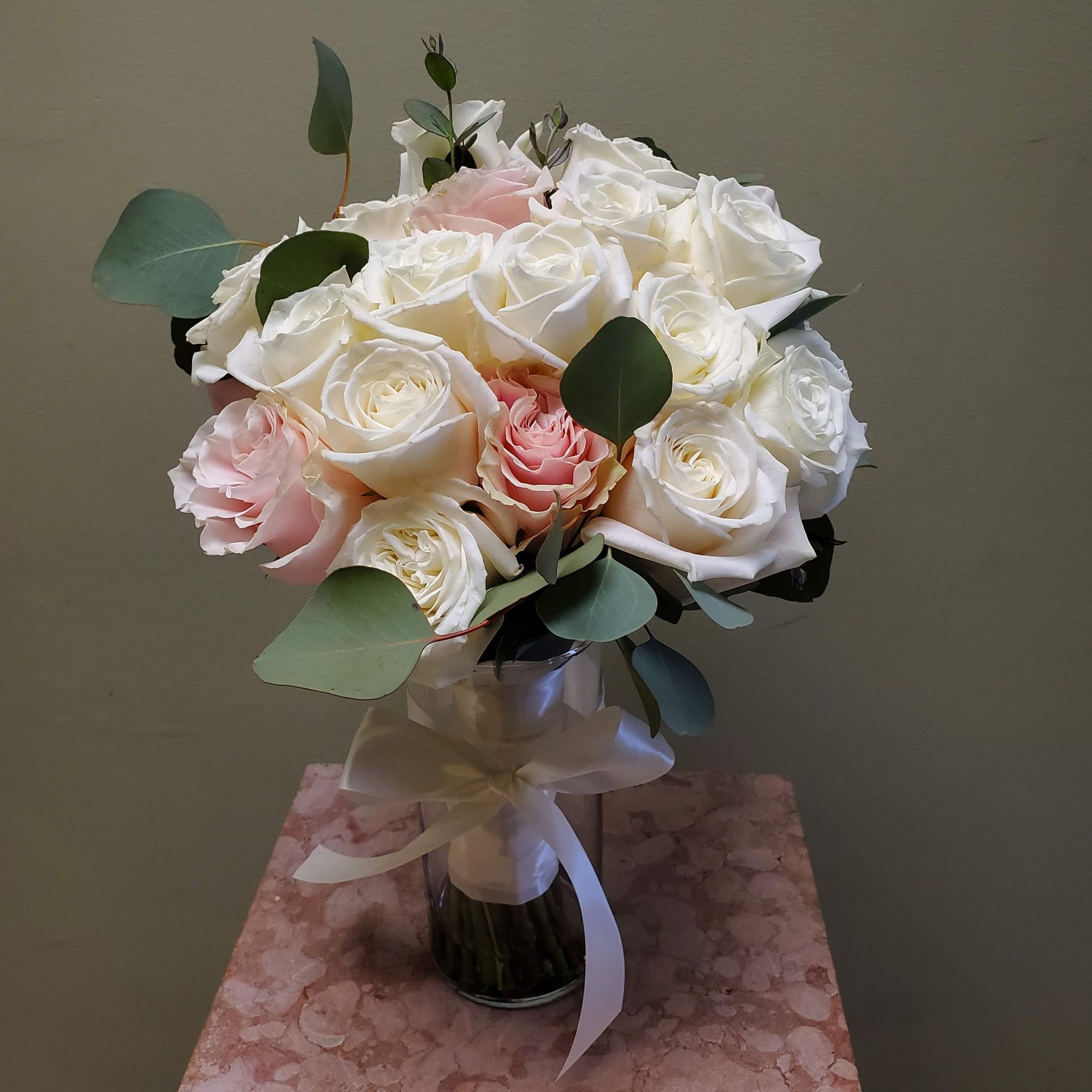 A bouquet of flowers is sitting on a wooden stool.