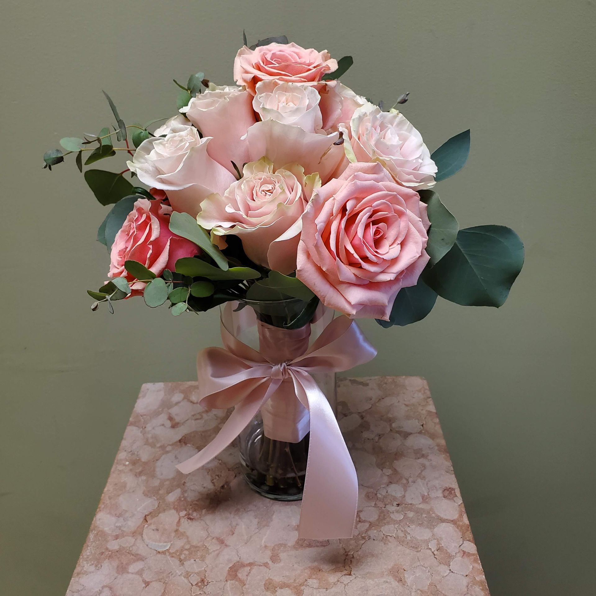 A bouquet of flowers is sitting on a wooden stool.