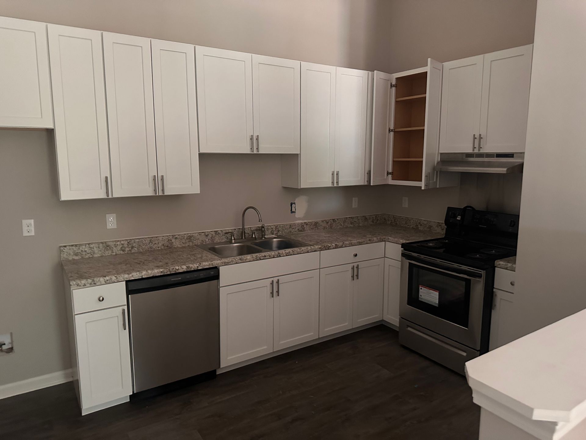 A kitchen with white cabinets and stainless steel appliances