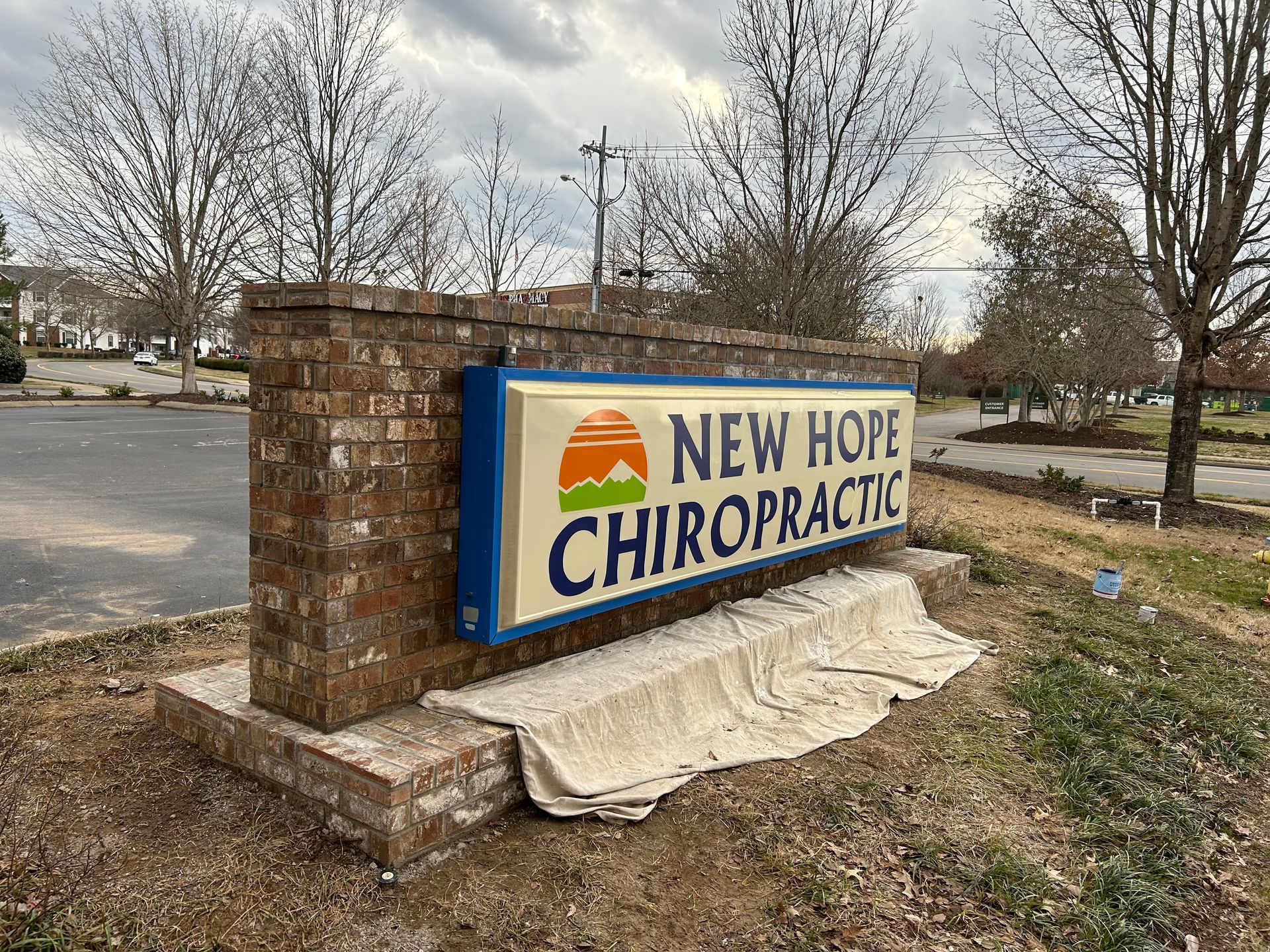 A new hope chiropractic sign is sitting on top of a brick wall.