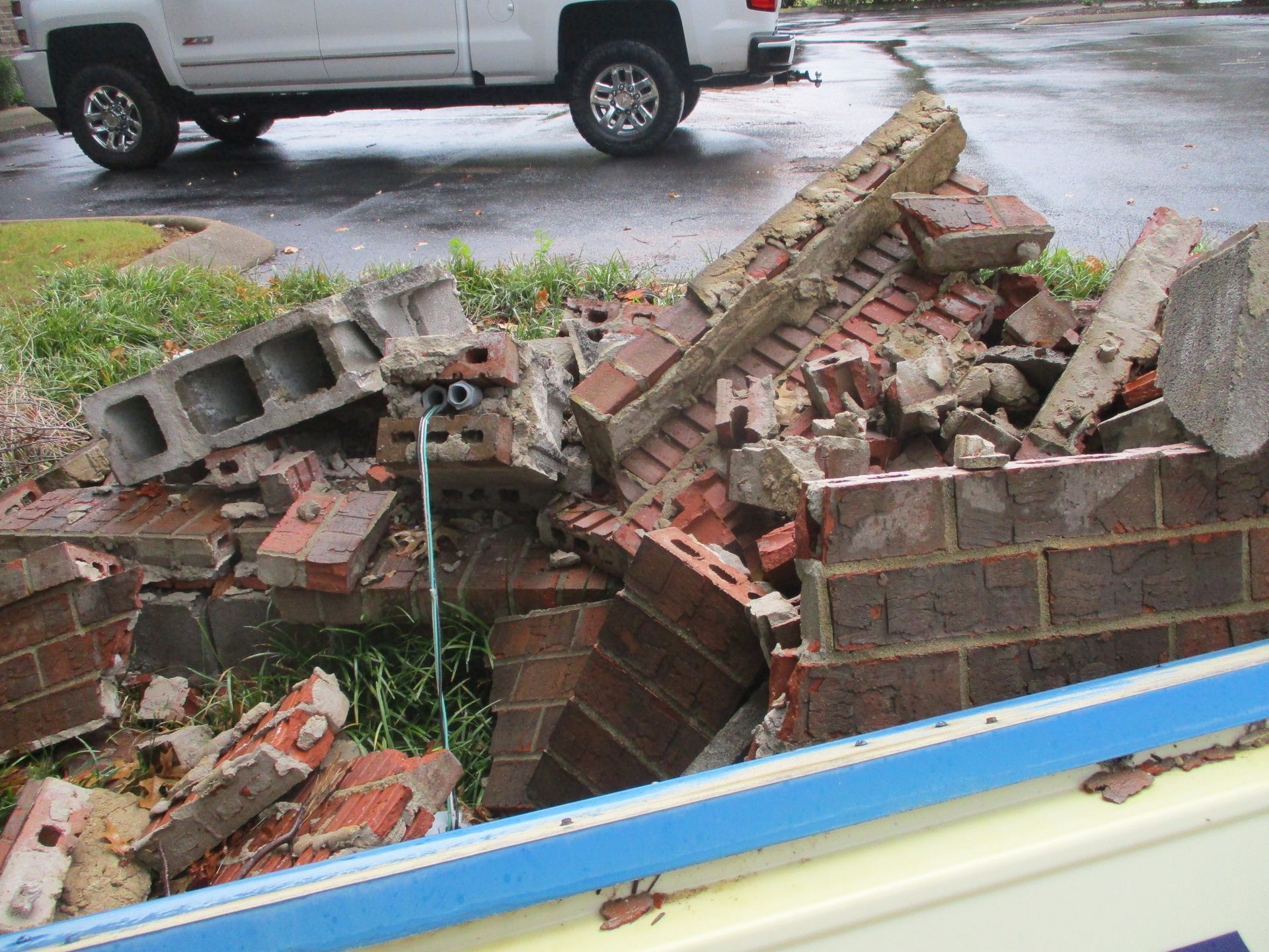 A white truck is parked next to a pile of bricks.