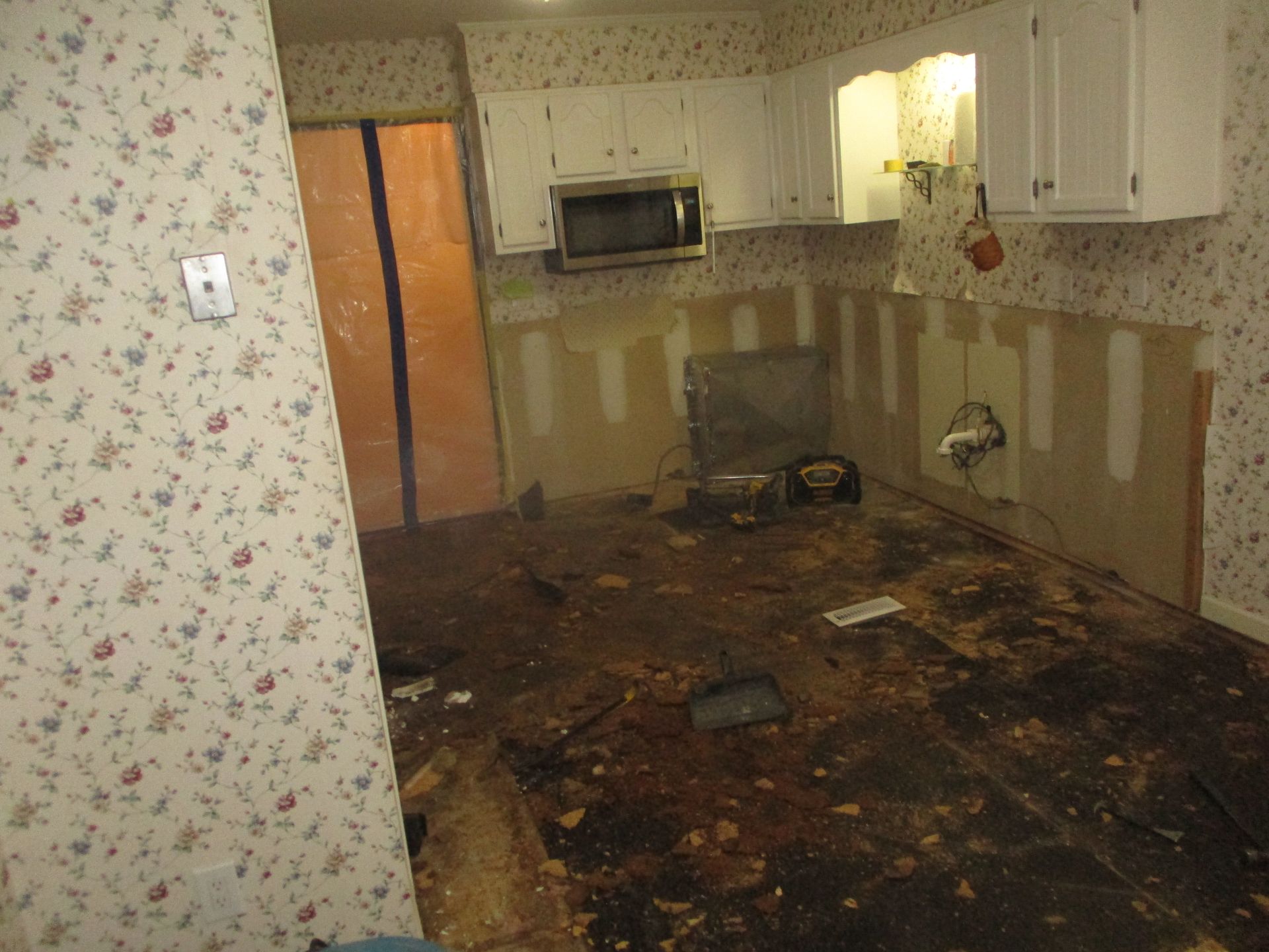 A kitchen with white cabinets and a microwave.