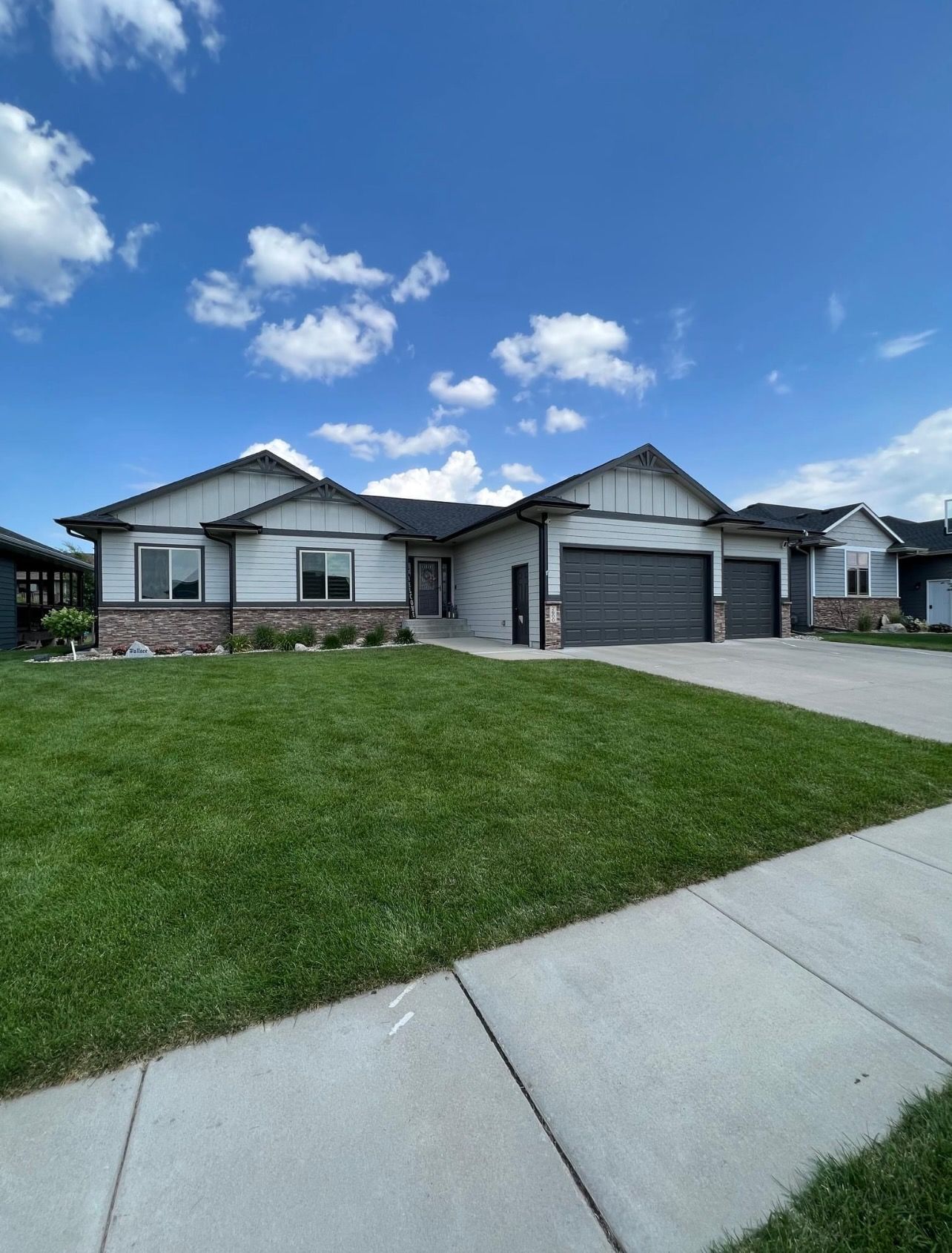 Tan-sided house with a deck and a cloudy sky. A window and sliding glass door are visible.