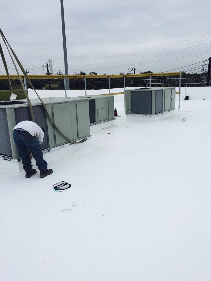 A man is working on the roof of a building