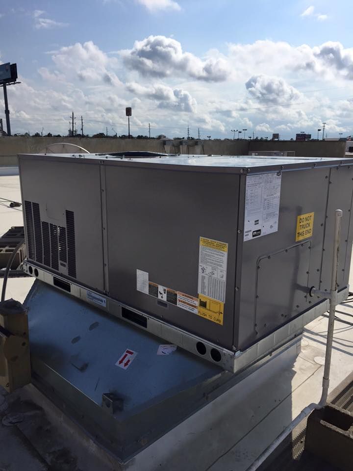 A large air conditioner is sitting on top of a roof.