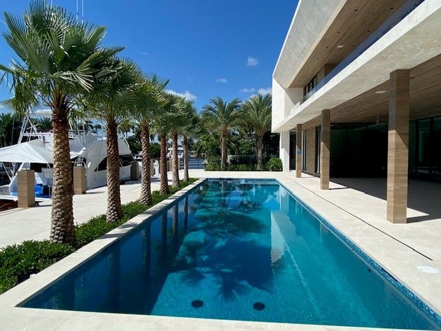 a large swimming pool is surrounded by palm trees