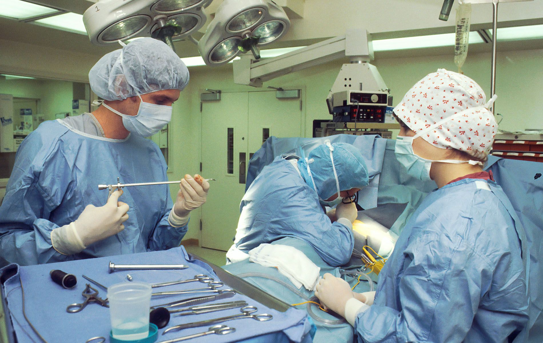 A group of surgeons are performing surgery in an operating room