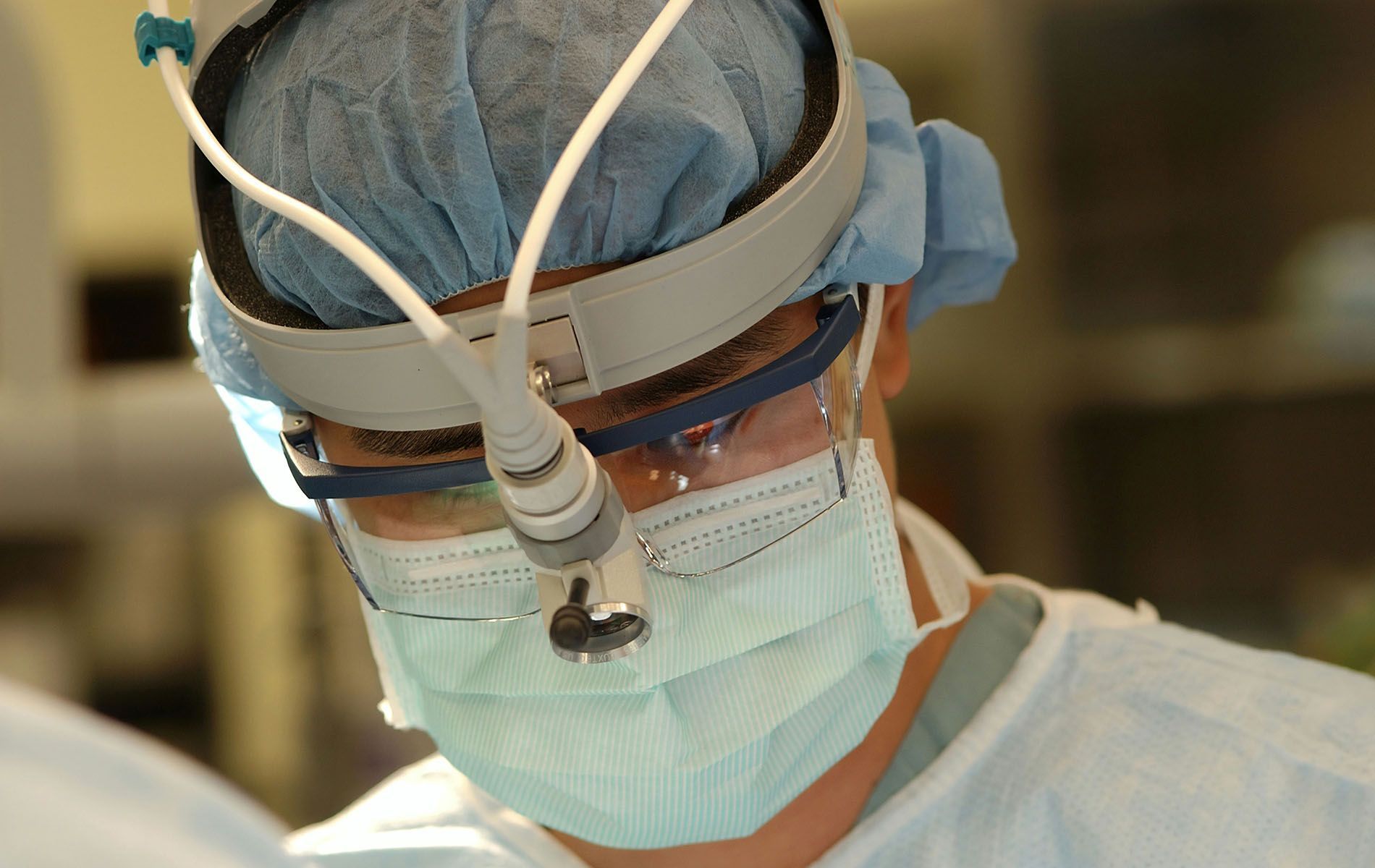 A close up of a surgeon wearing a mask and goggles