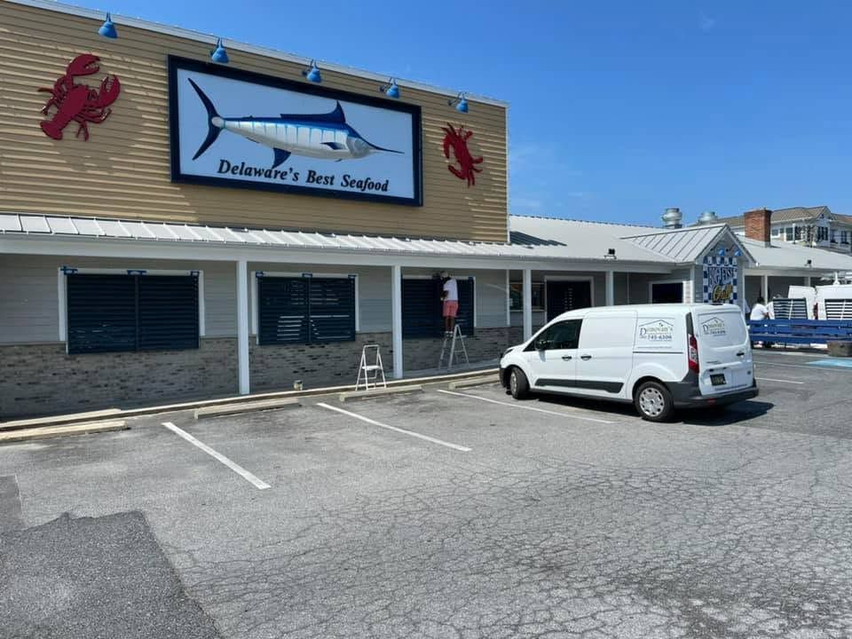Exterior of a seafood restaurant with a white van parked outside on a sunny day