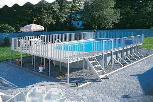 A large swimming pool with a deck and umbrella