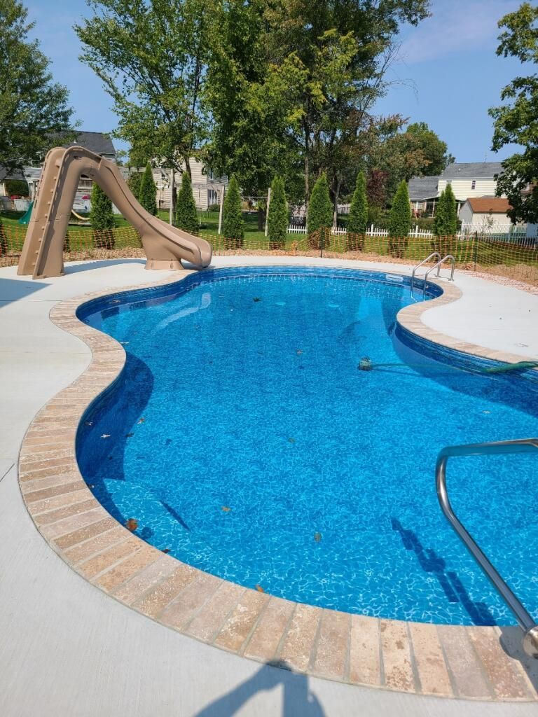A large swimming pool with a slide in the middle of it.