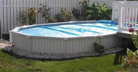 A large swimming pool is sitting on top of a lush green lawn