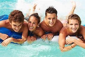 A group of young people are laying on rafts in a swimming pool