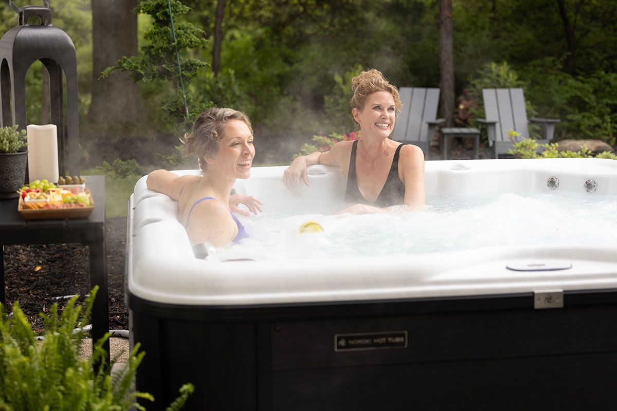 Two women are sitting in a hot tub