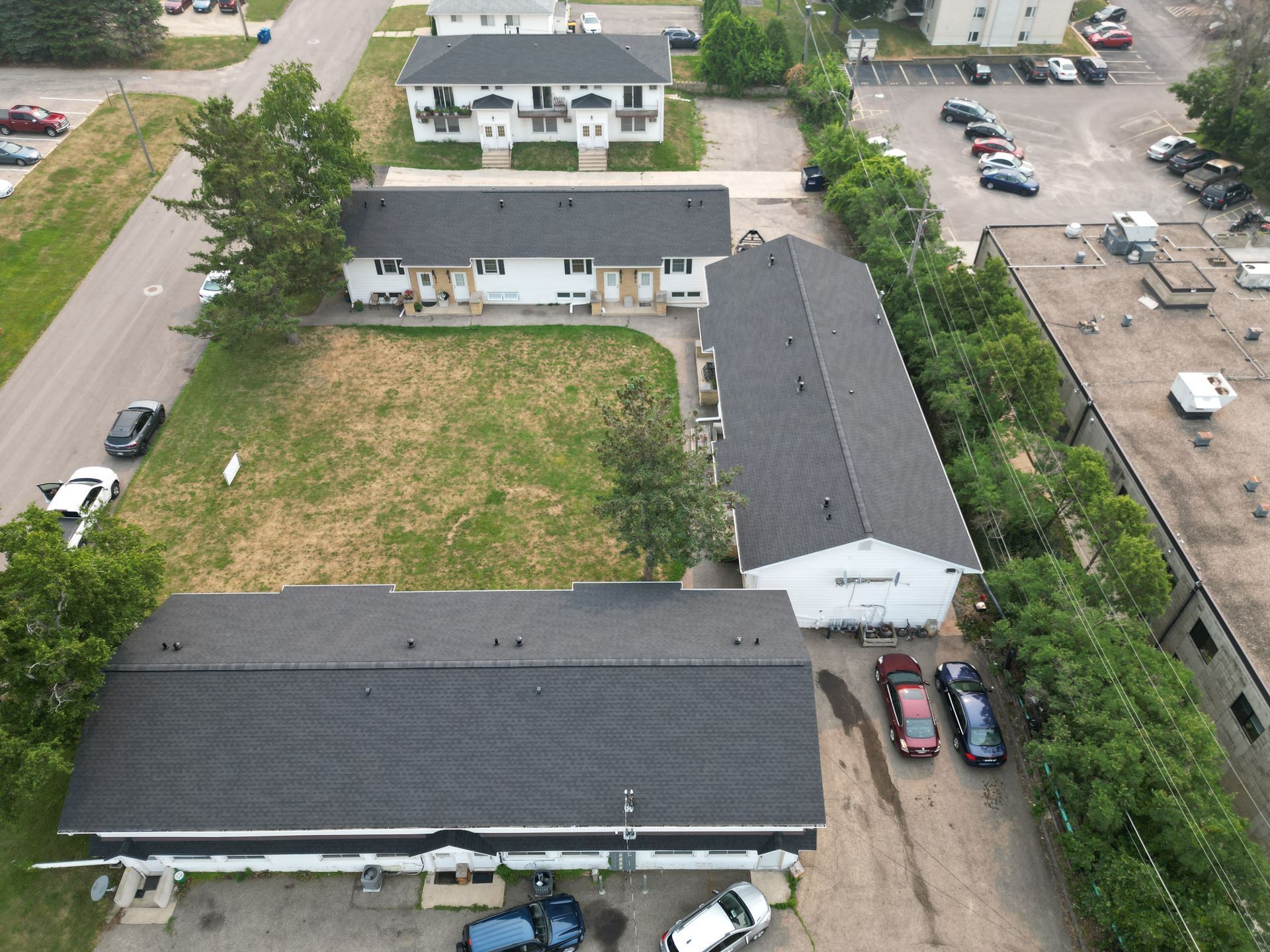 An aerial view of a row of buildings with cars parked in front of them