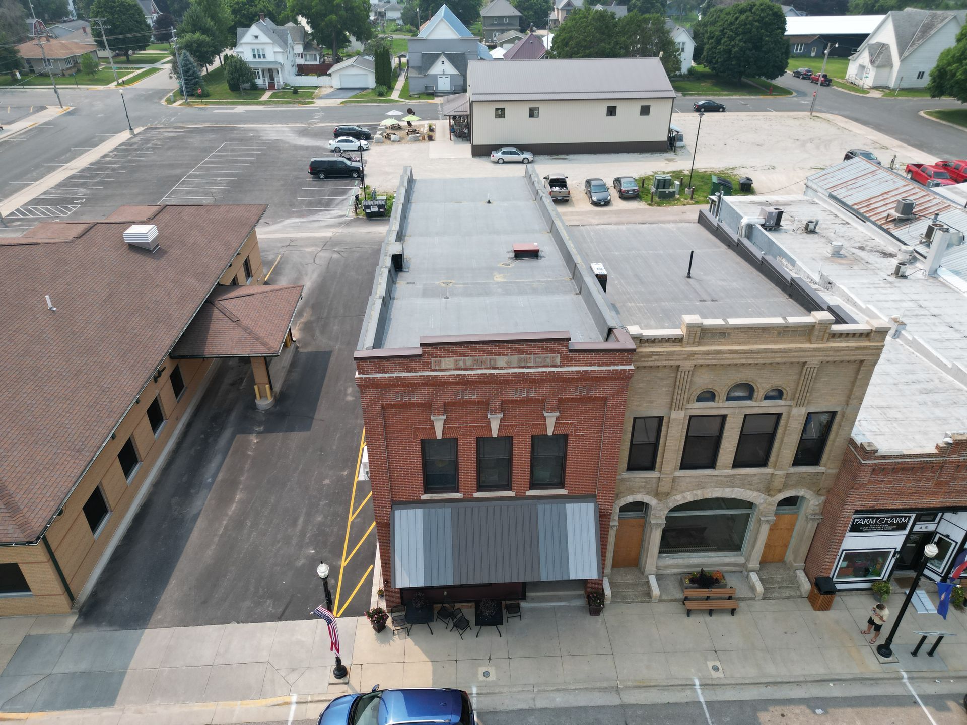 An aerial view of a small town with a blue car parked in front of a building