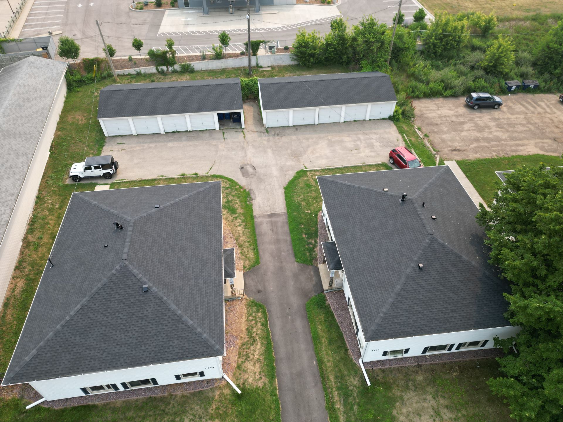 An aerial view of a row of houses with black roofs