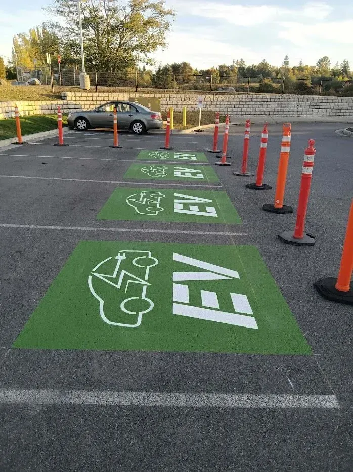 Parking spaces reserved for electric vehicles, marked with green paint and EV symbols.