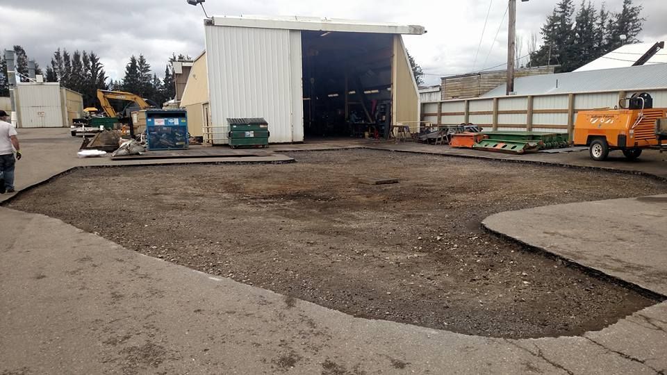 An asphalt lot with a building and equipment.