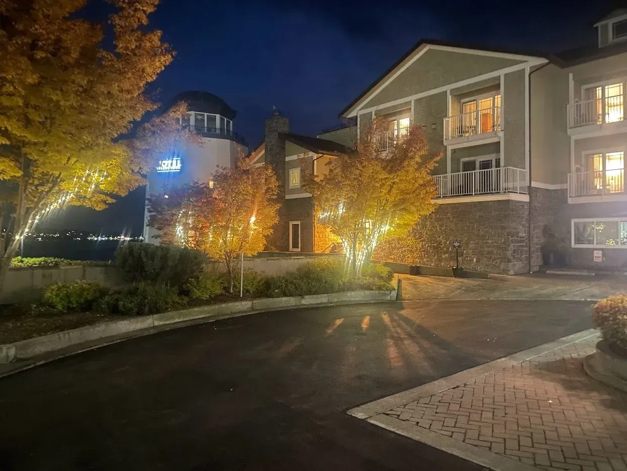 Building exterior at dusk with autumn trees illuminated.