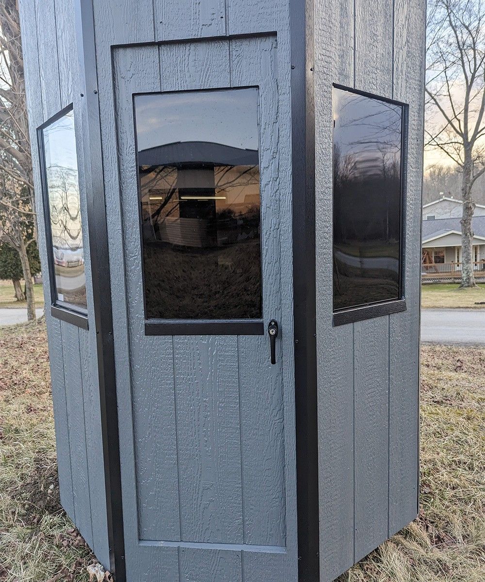 Gray polygonal hunting blind with black trim and tinted windows.