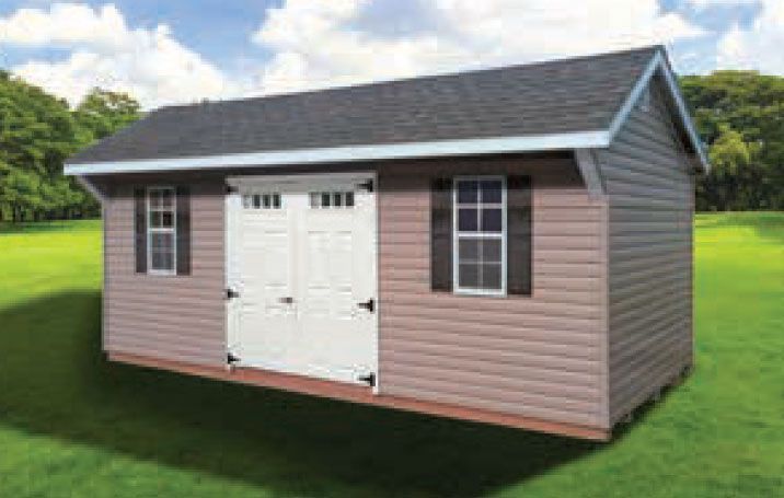 Tan shed with a black roof, white doors, and black shutters on a green lawn.