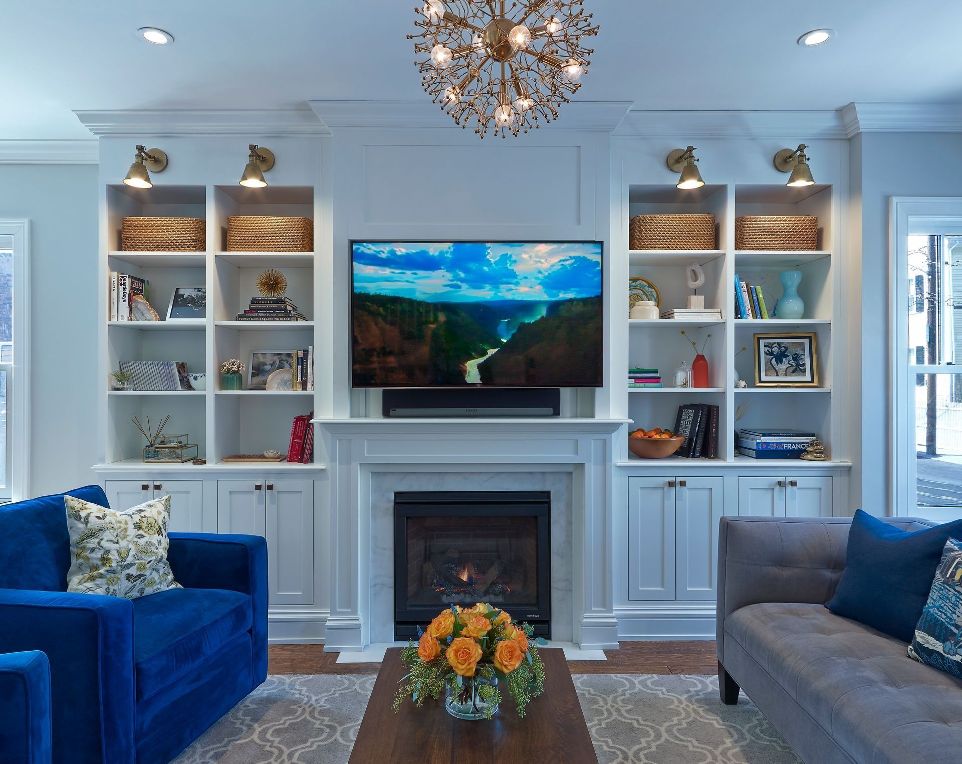 Bright living room with white built-in shelves, fireplace, and a guitar on the hearth.
