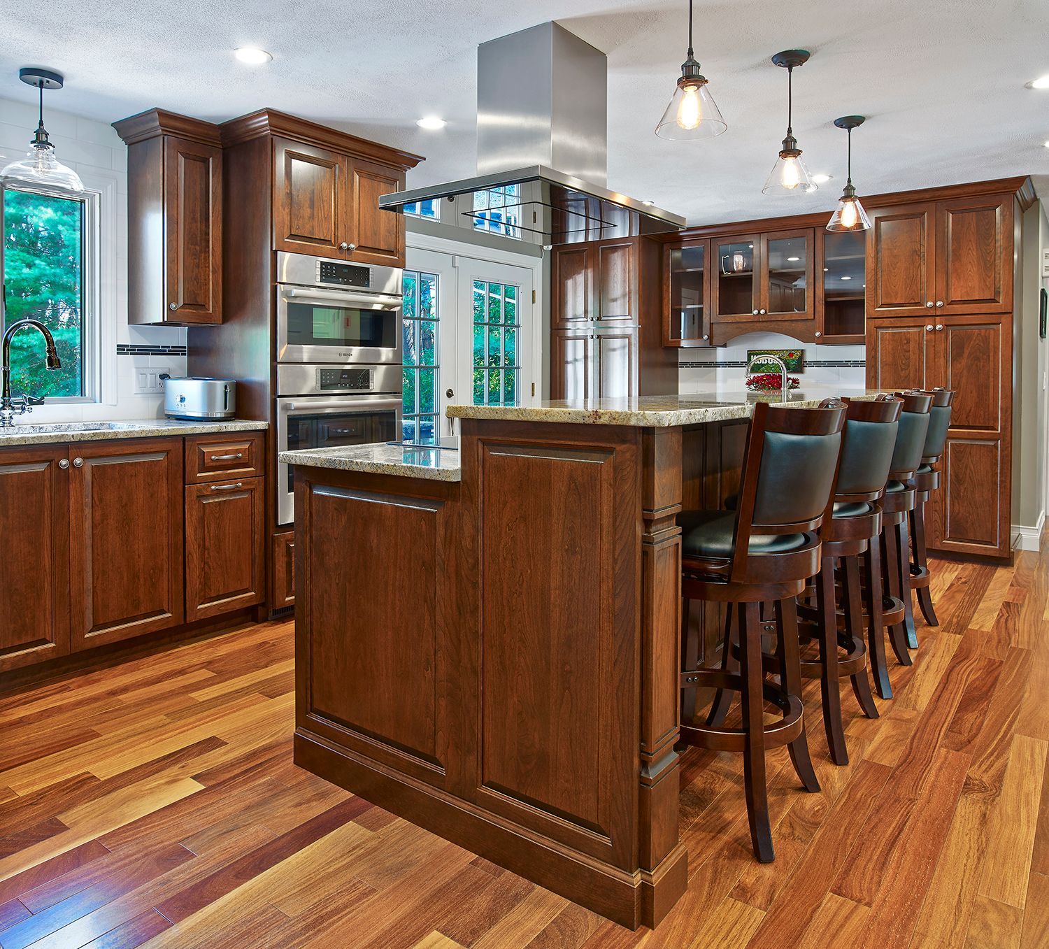 Modern kitchen with dark wood cabinets, island seating, and hardwood floors