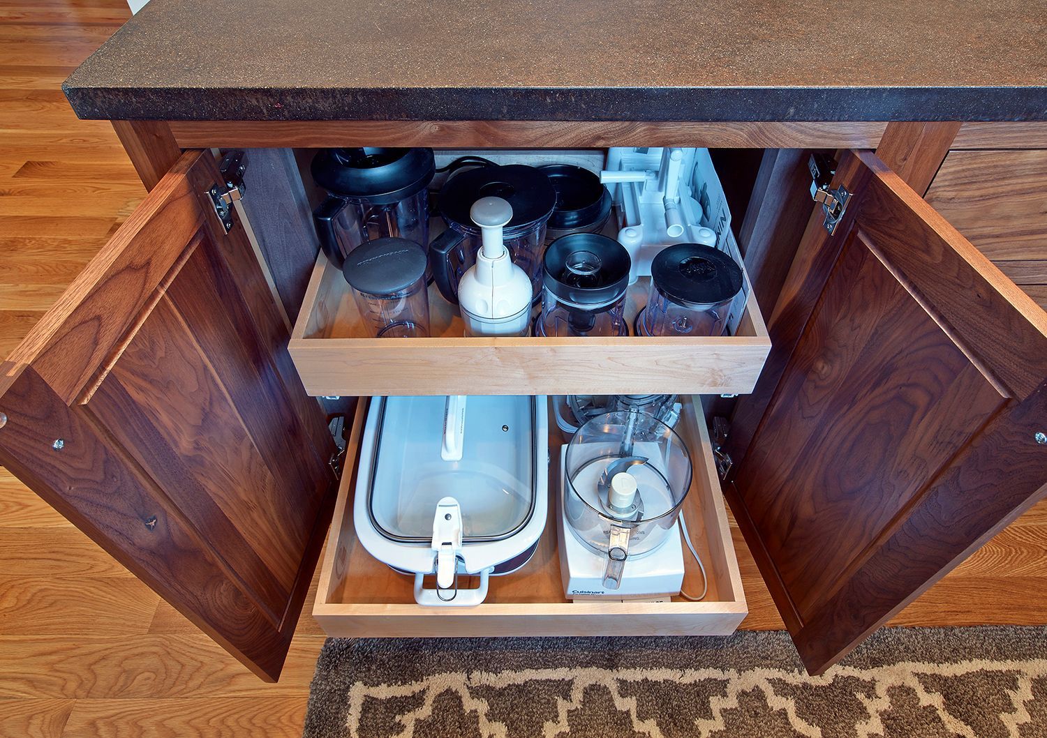 Open wooden cabinet with shelves holding kitchen utensils and bottles inside.