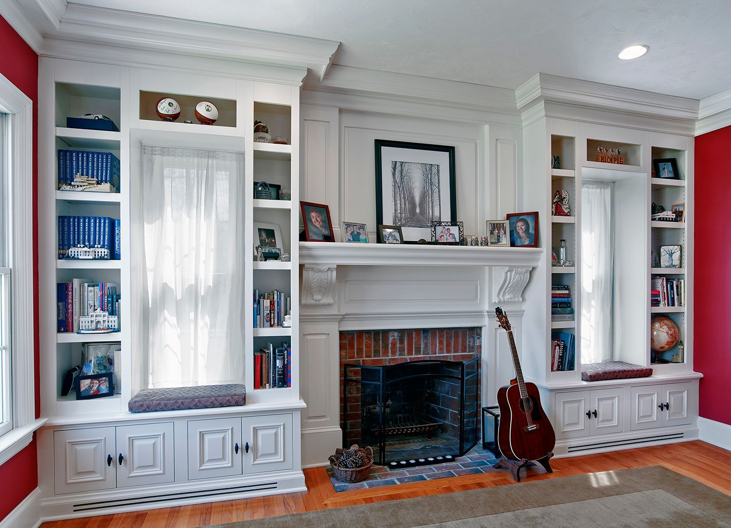 Living room built-ins flanking a fireplace, with books, decor, and guitars in front.