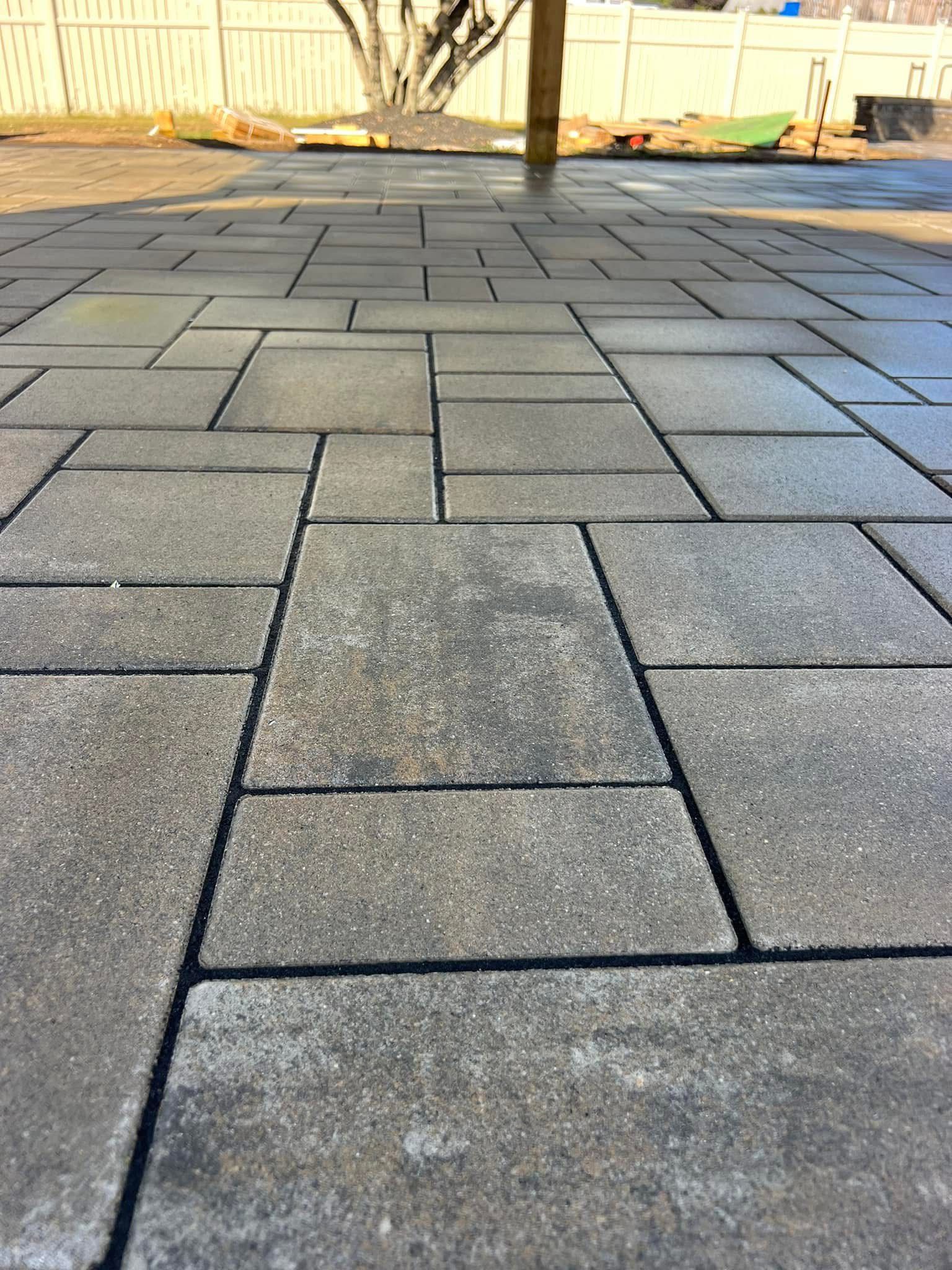 Close-up view of a gray brick patio with various rectangular and square pavers.