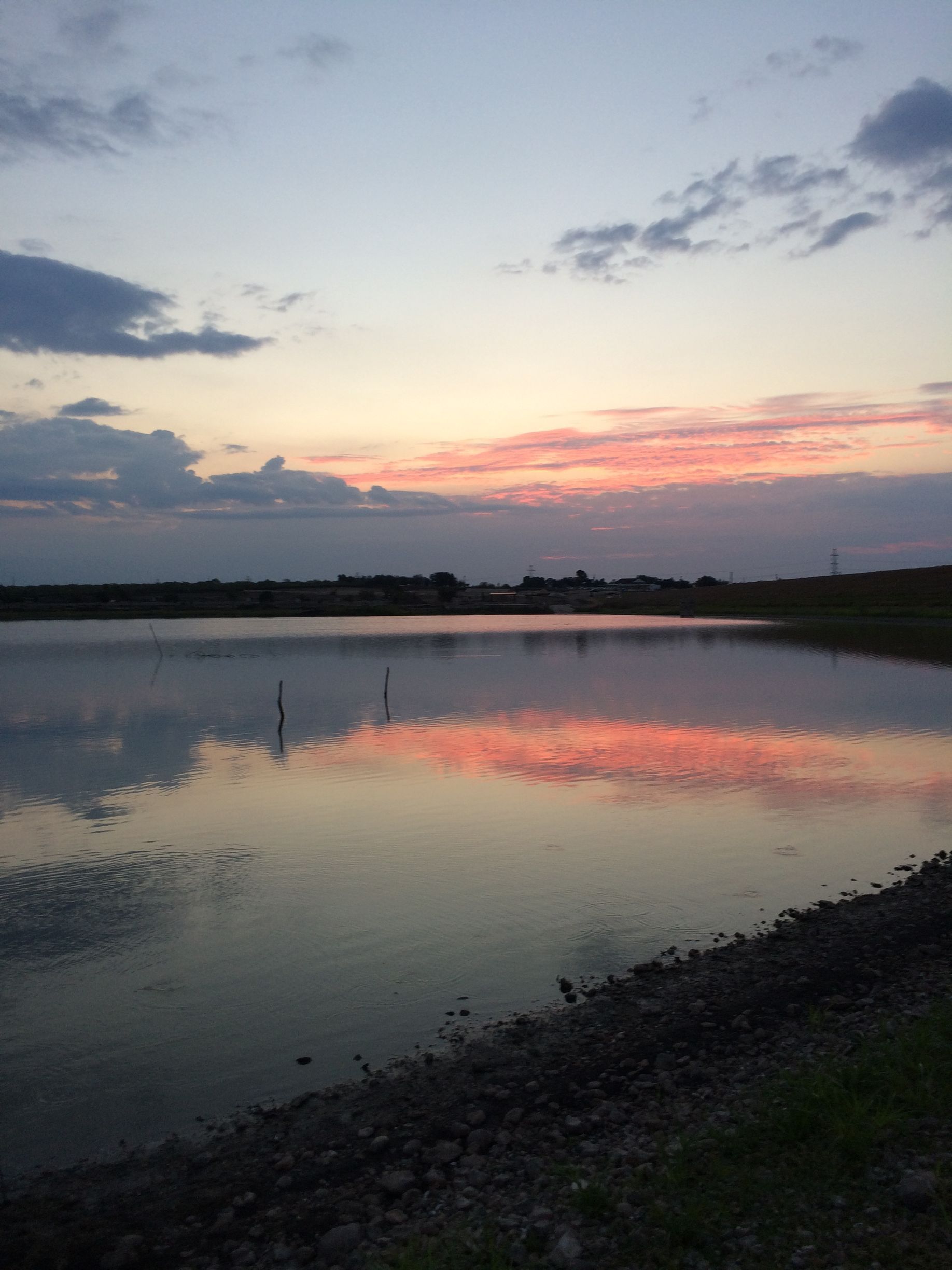 A large body of water with a sunset in the background