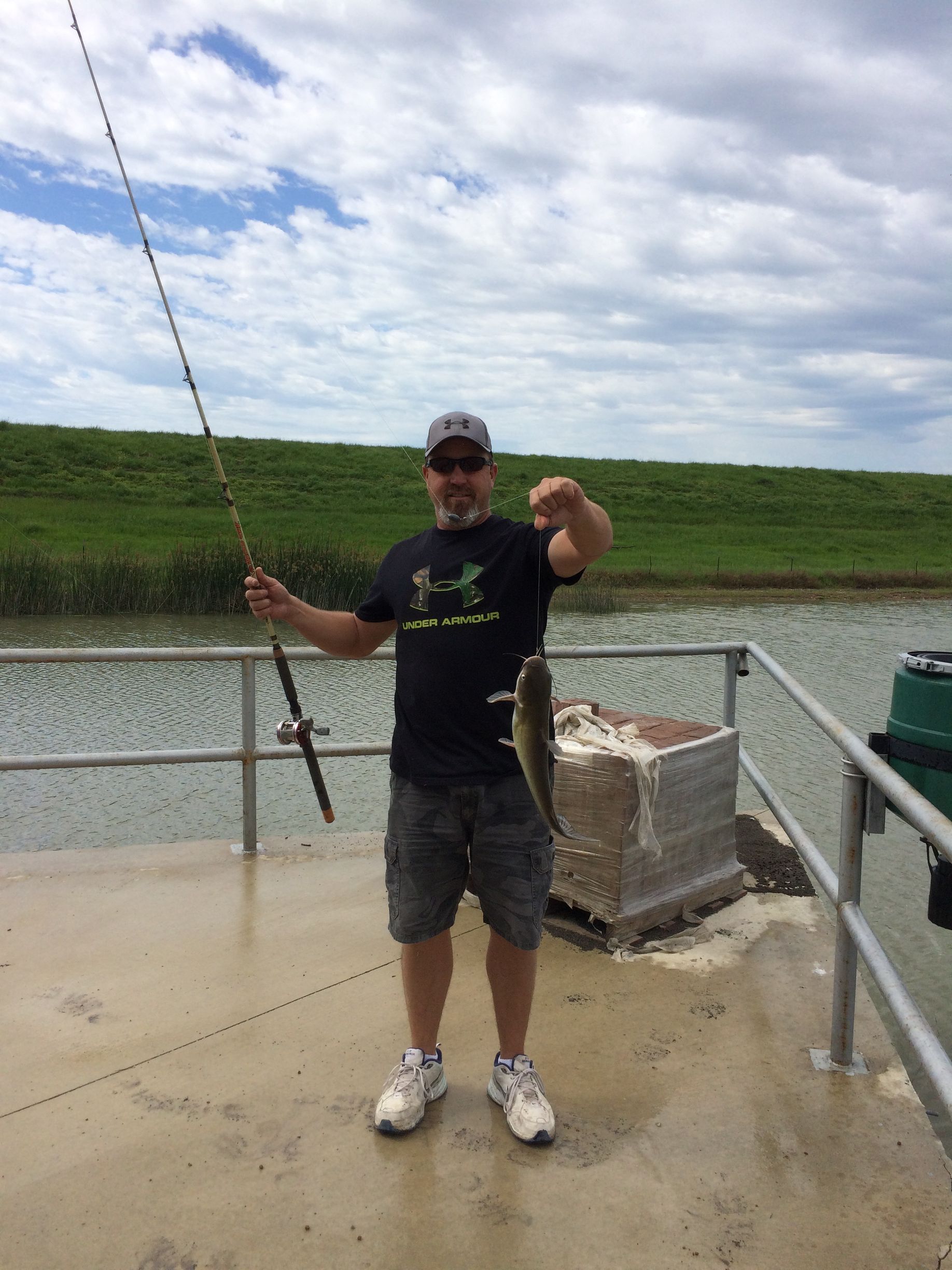 A man is holding a fishing rod and a fish