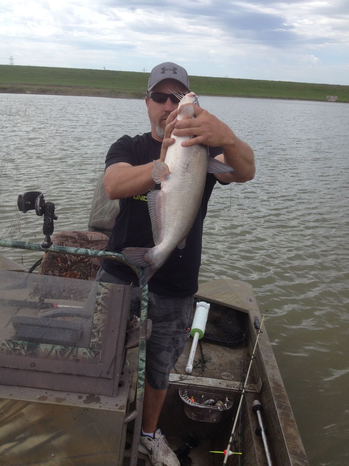 A man in a boat is holding a large fish