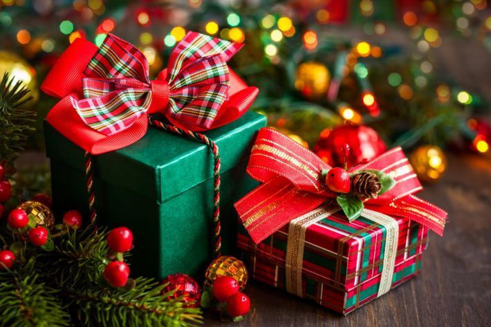 Two Christmas presents are sitting on a wooden table