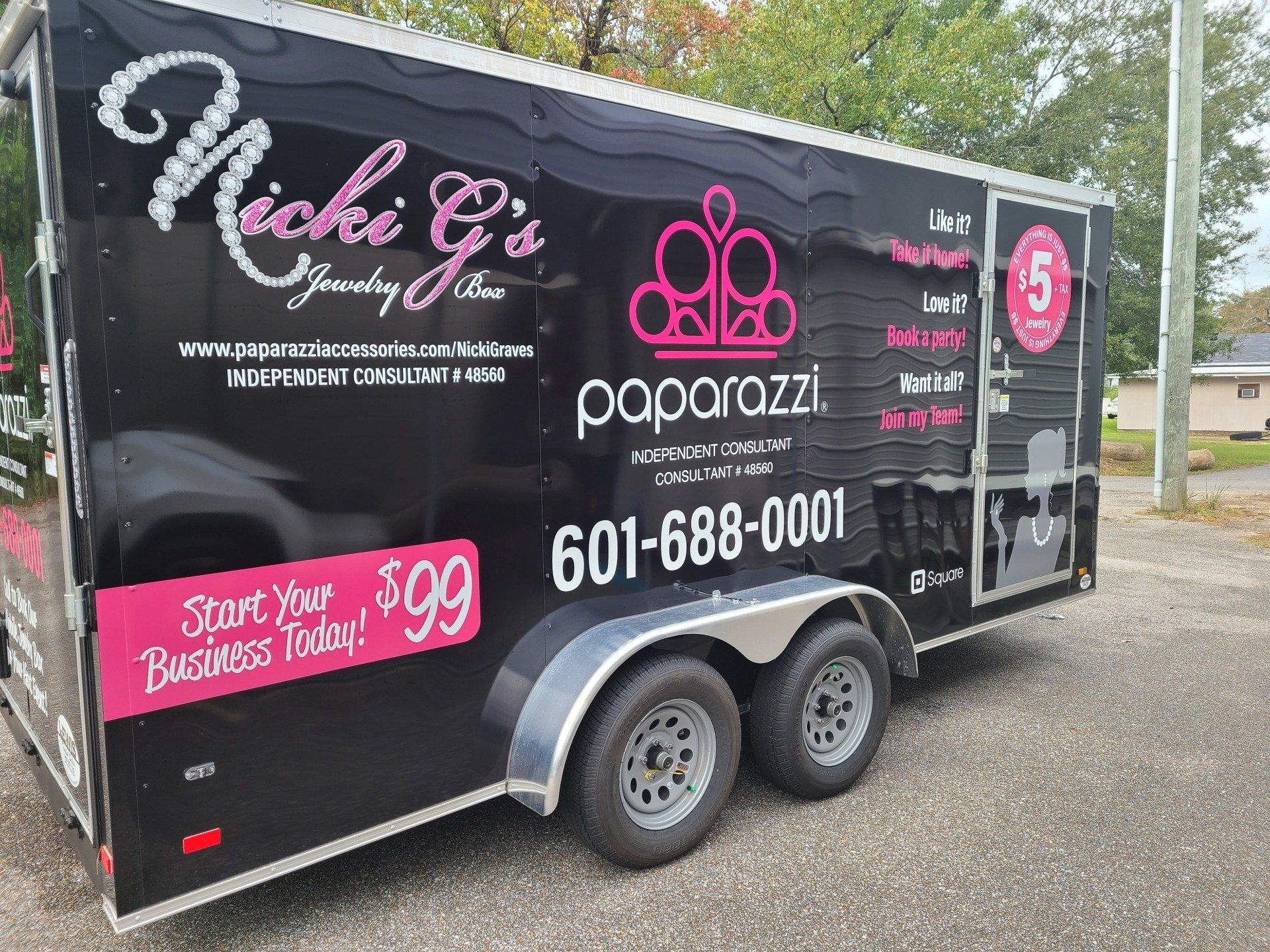 A paparazzi trailer is parked on the side of the road.