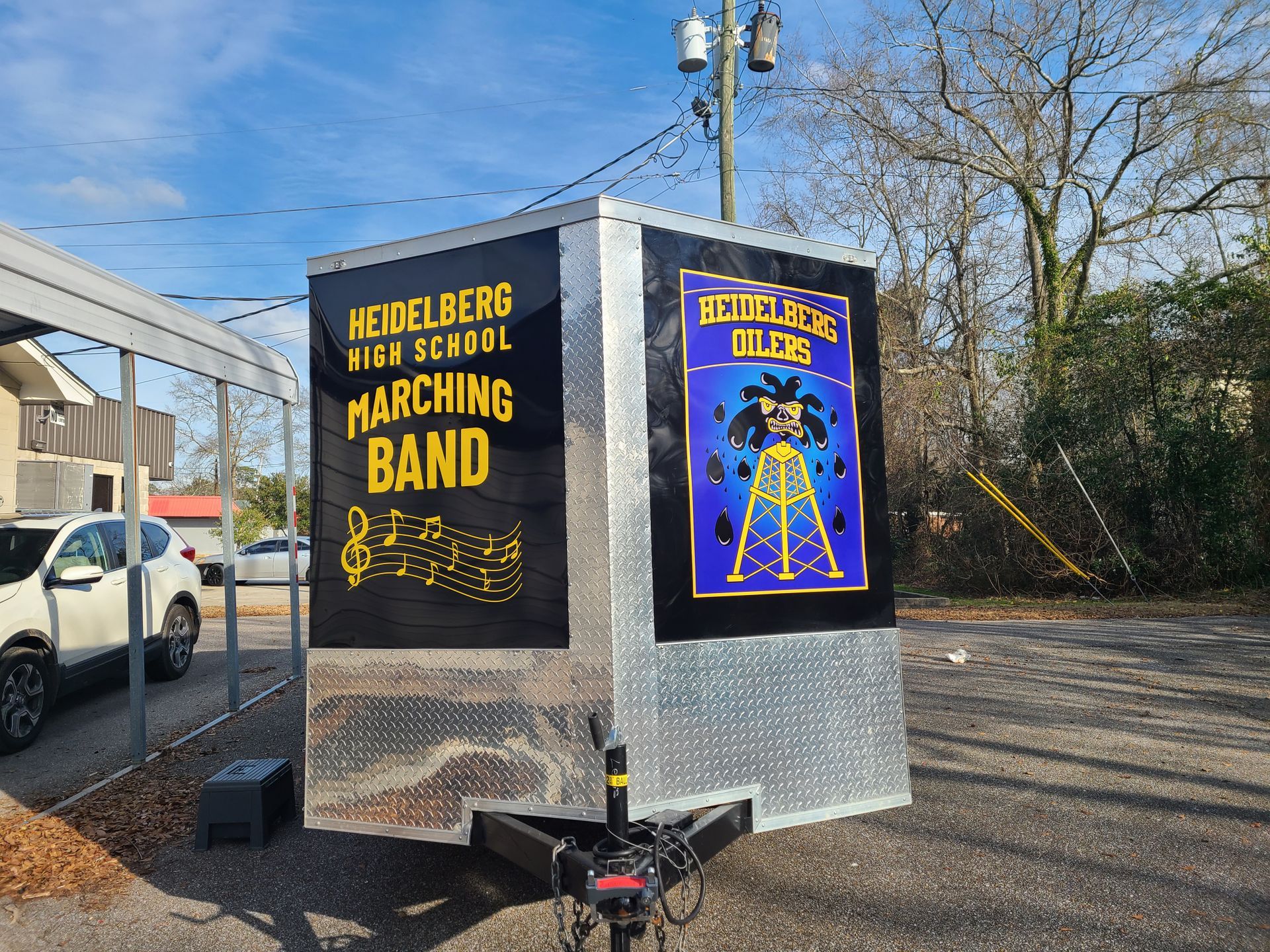 A heidelberg high school marching band trailer is parked in a parking lot.