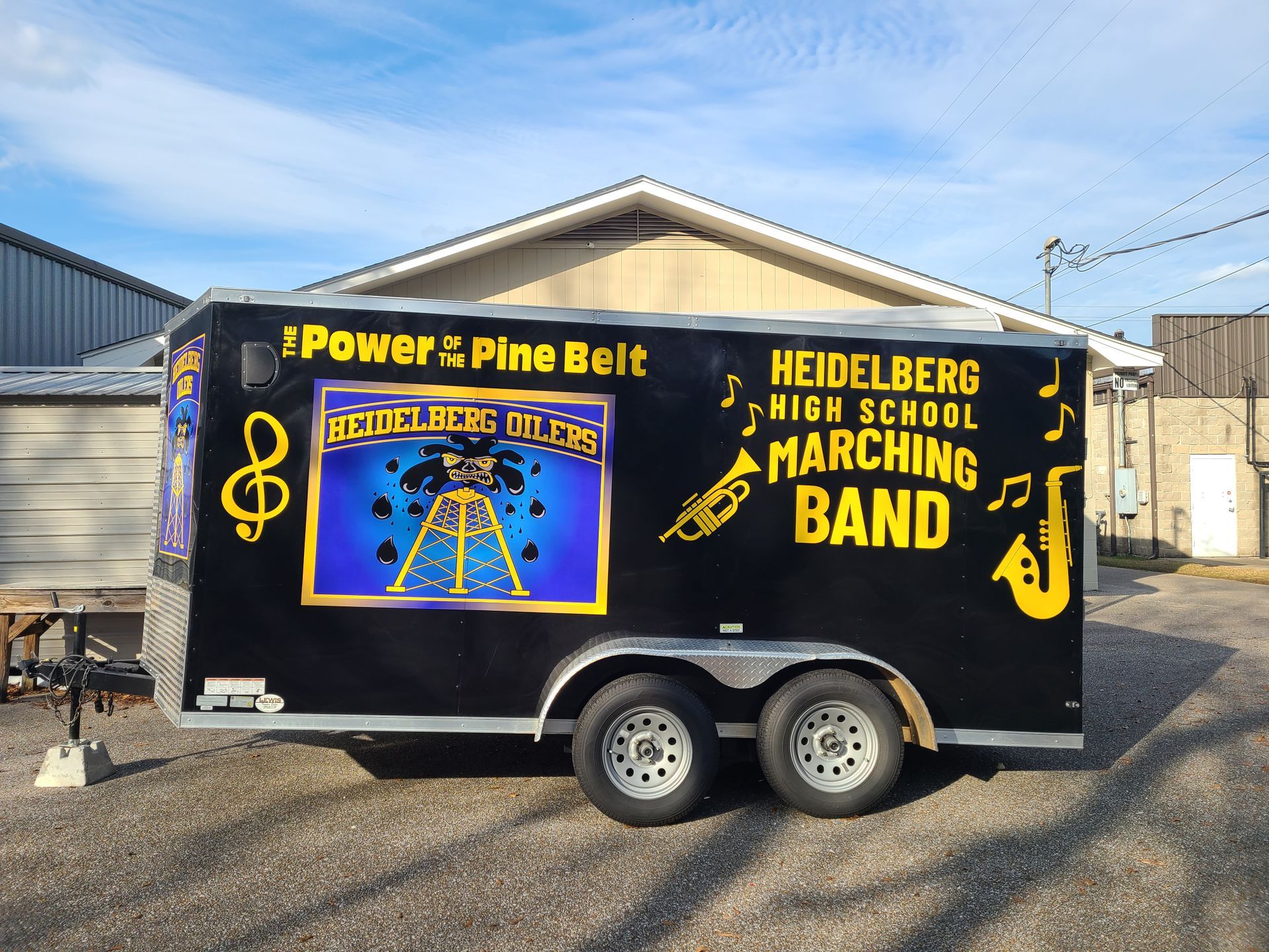 A heidelberg high school marching band trailer is parked in front of a building