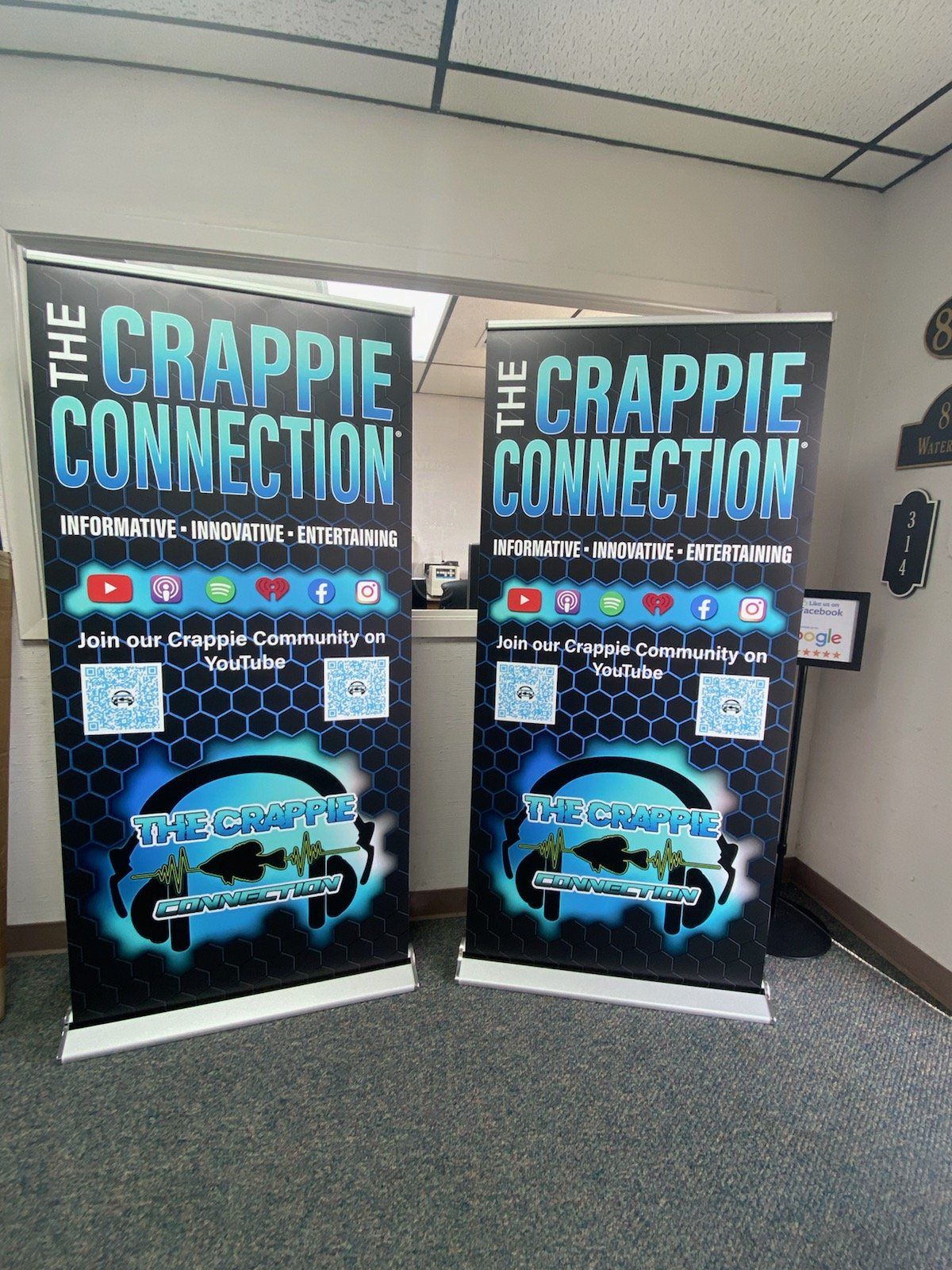 Two posters for the crappie connection are displayed in a room.