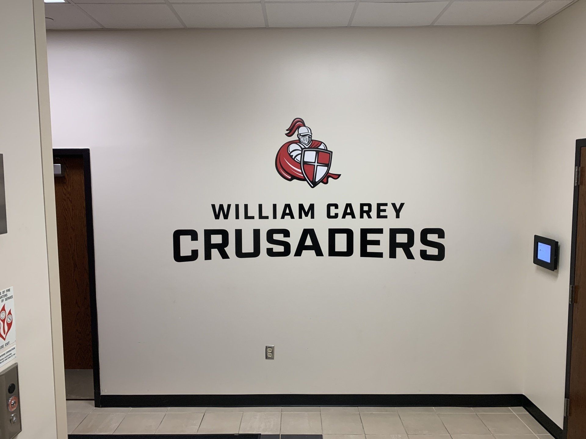 A wall with a logo for the william carey crusaders