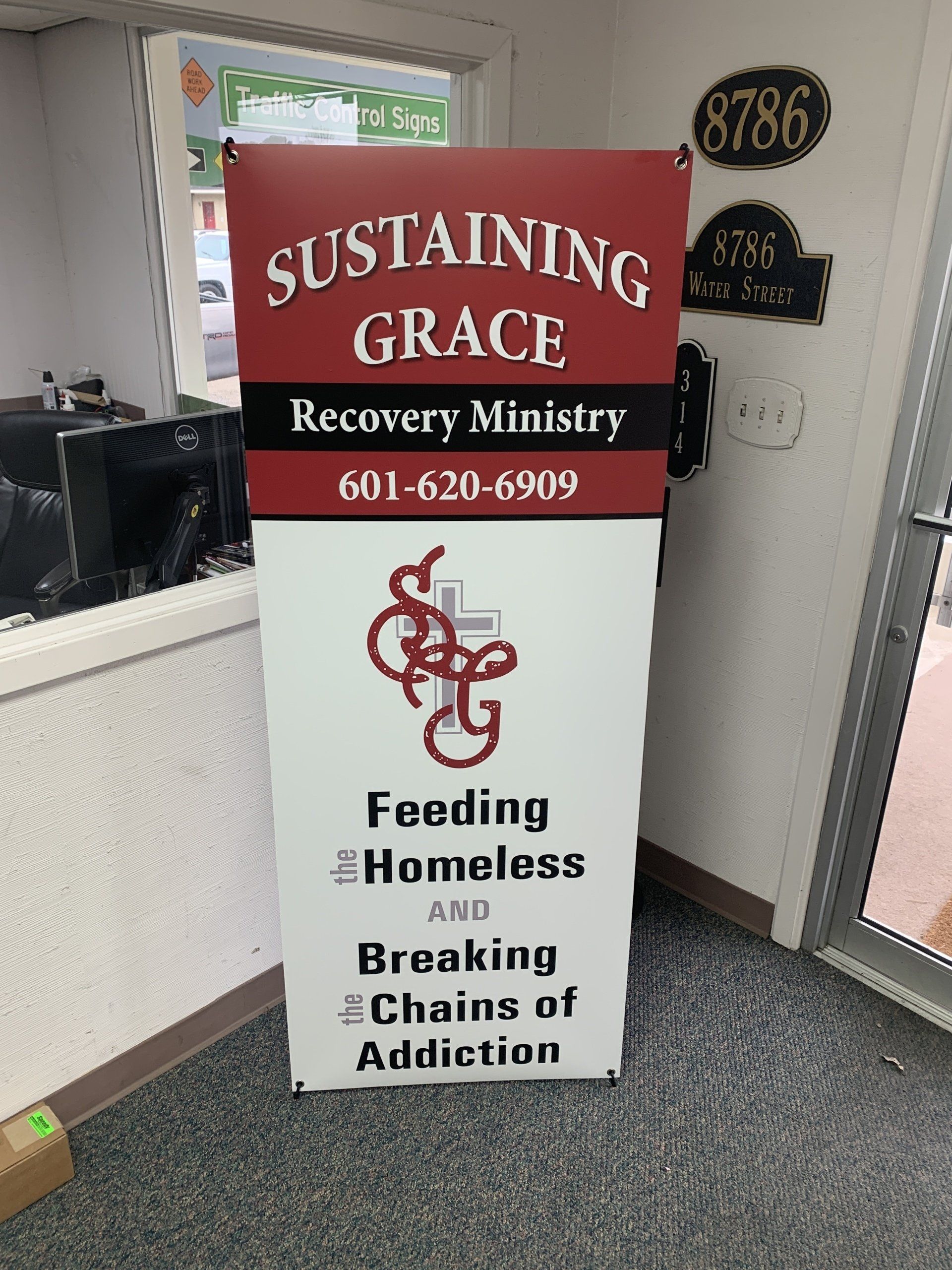 A sign that says ' sustaining grace recovery ministry ' on it