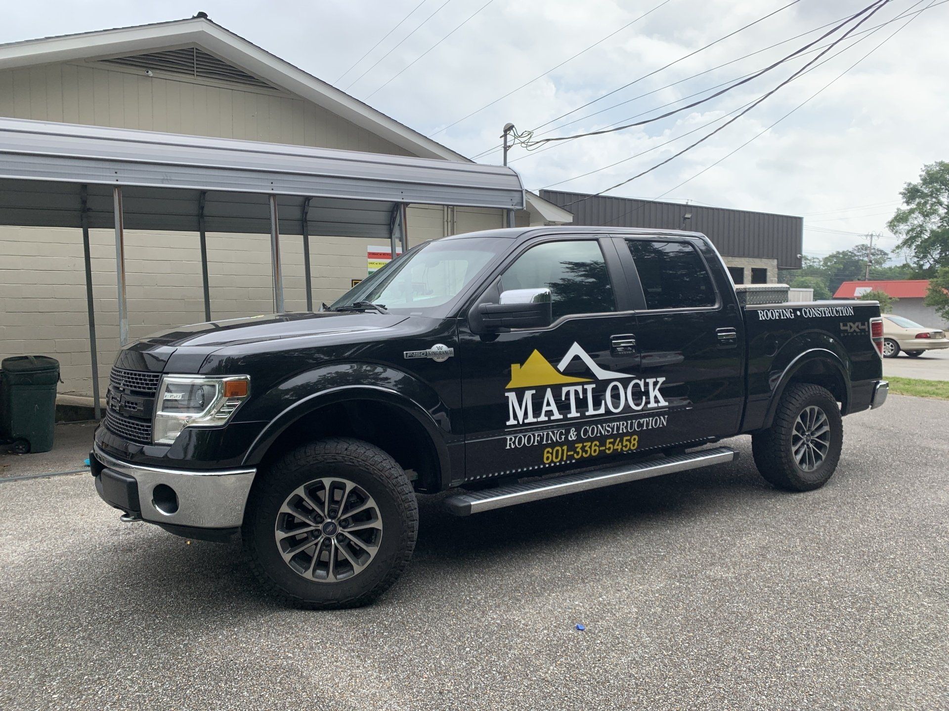 A black pickup truck is parked in front of a building.