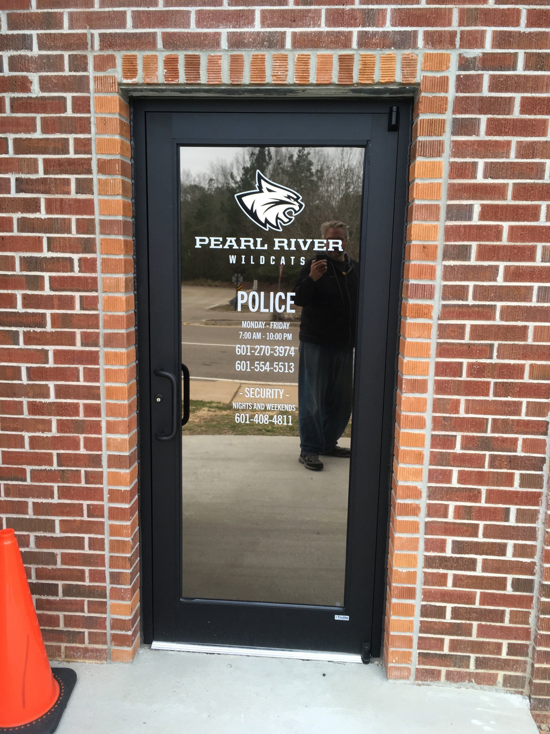 A brick building with a glass door that says pearl river police