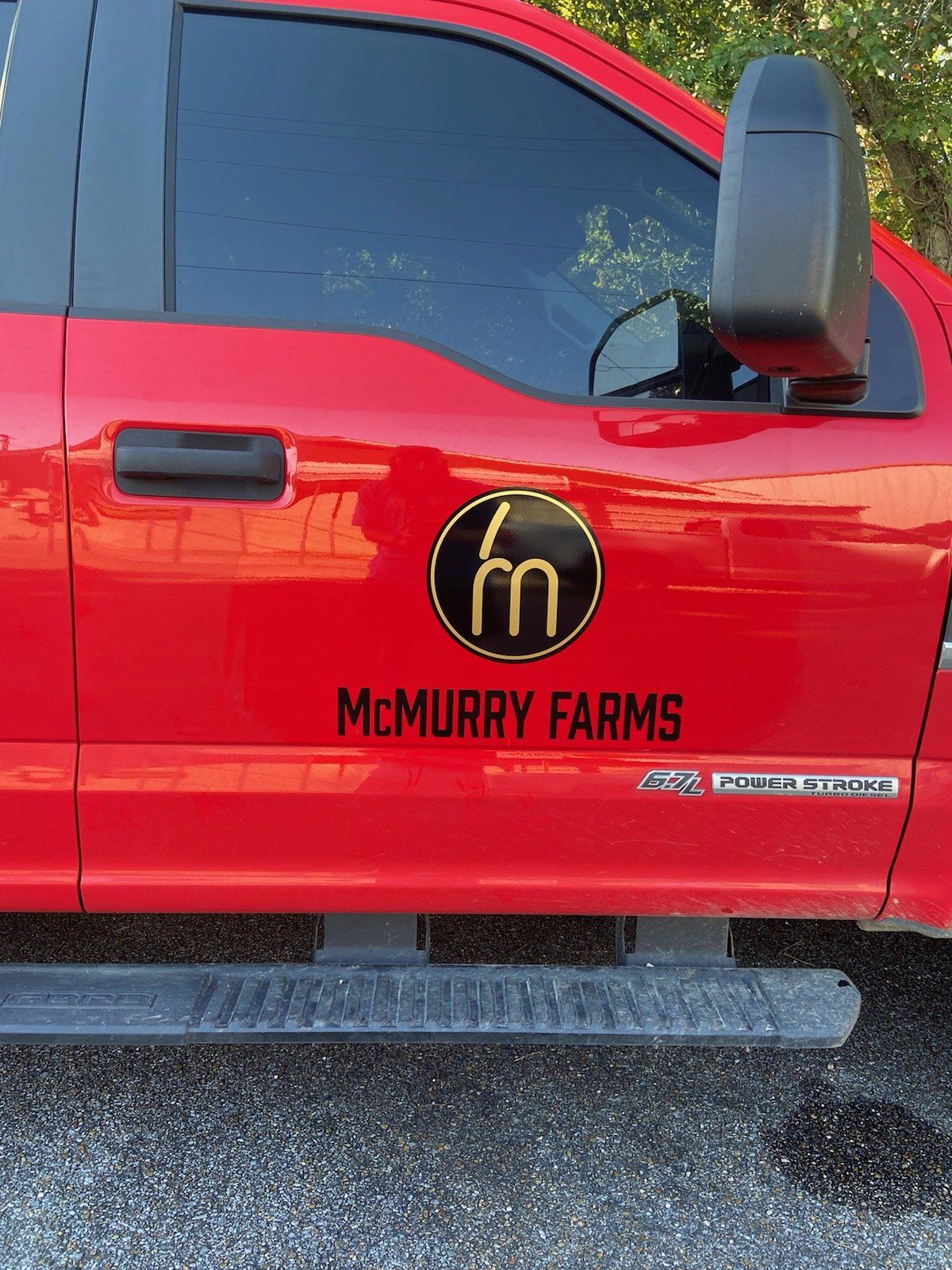 A red truck with a sticker on the side that says mcmurry farms