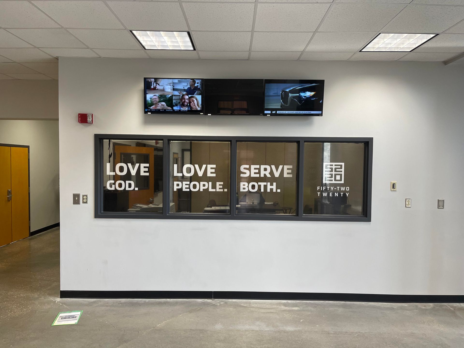 A room with a sign that says love god love people serve both