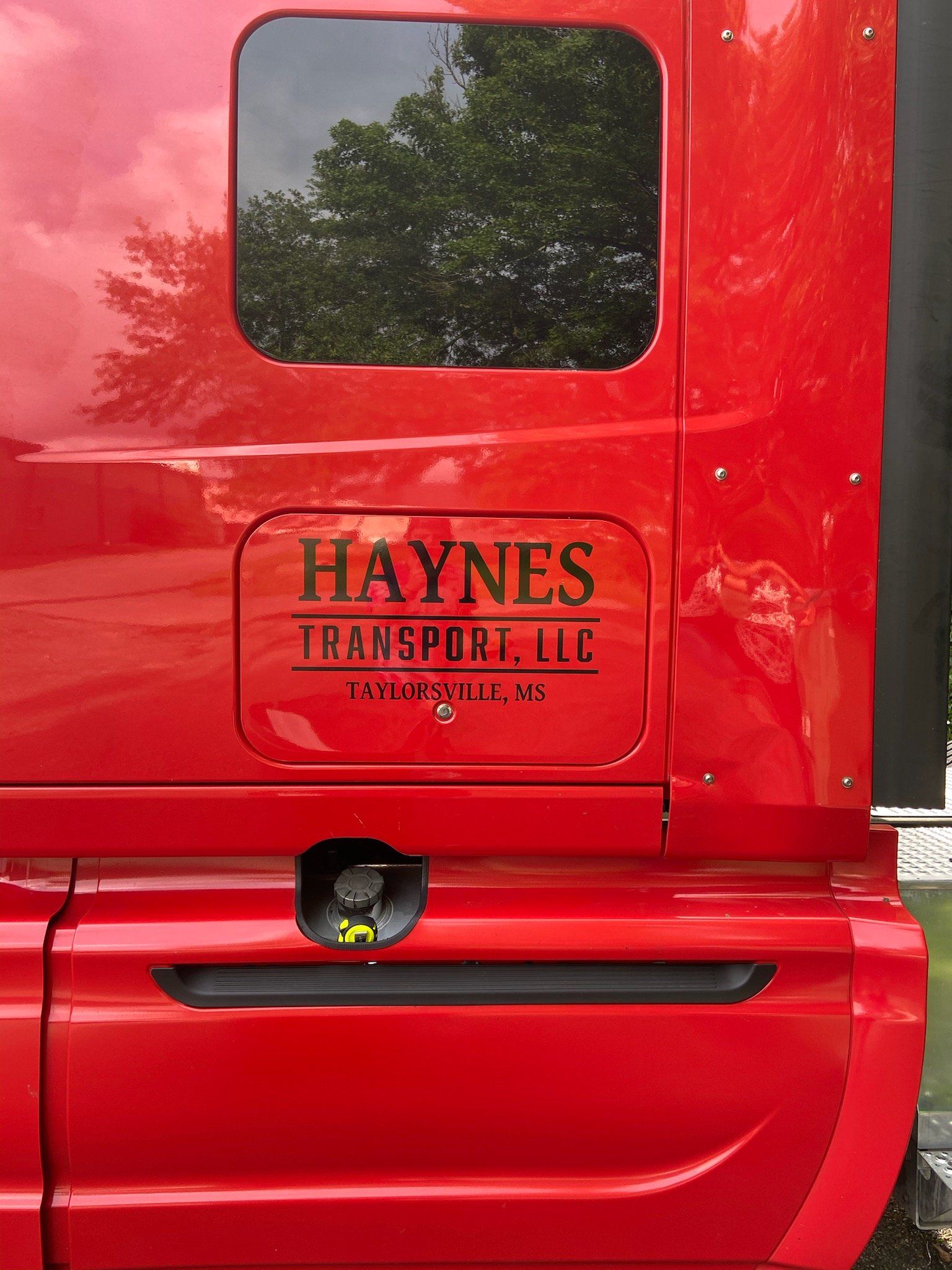 A red truck with a sticker on the side that says haynes transport , llc.