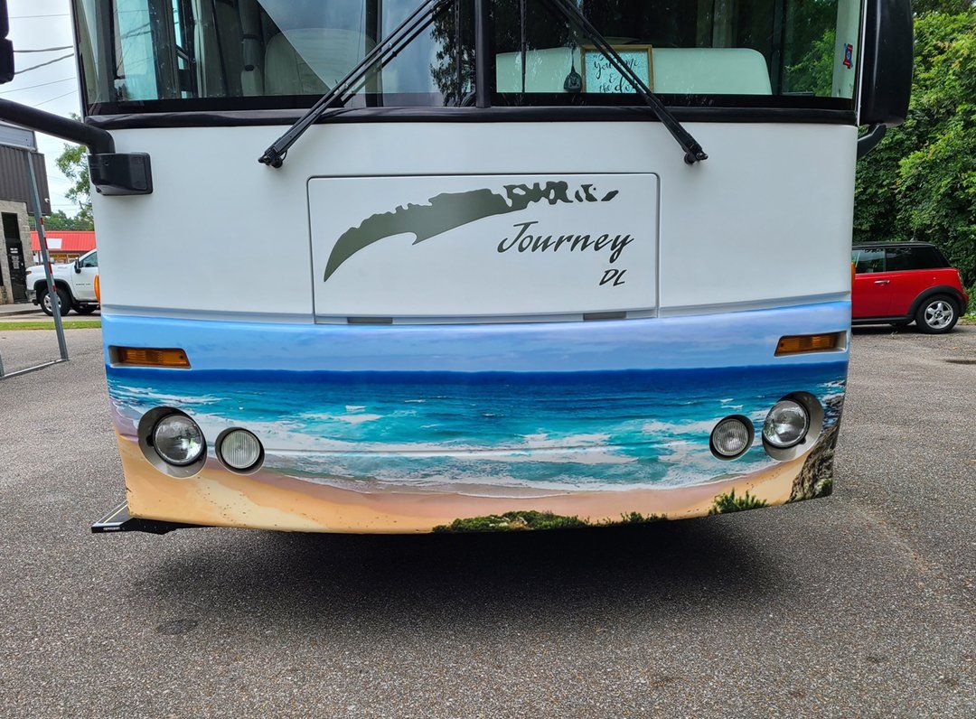 A white bus with a beach scene painted on it