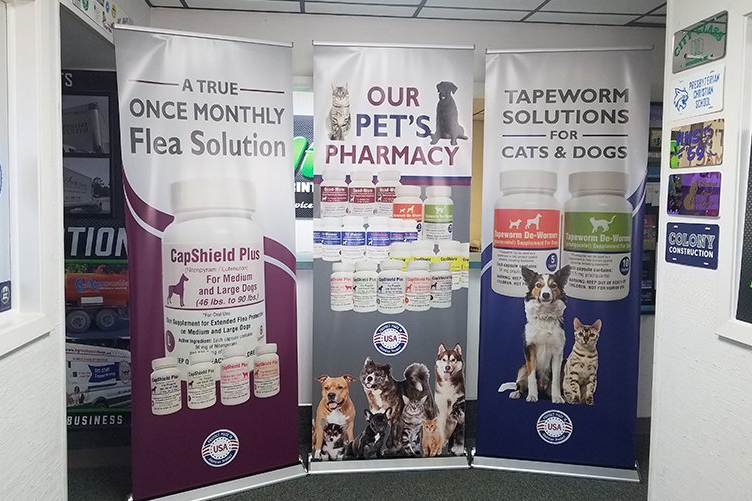 Three banners are hanging in a hallway in a pharmacy.