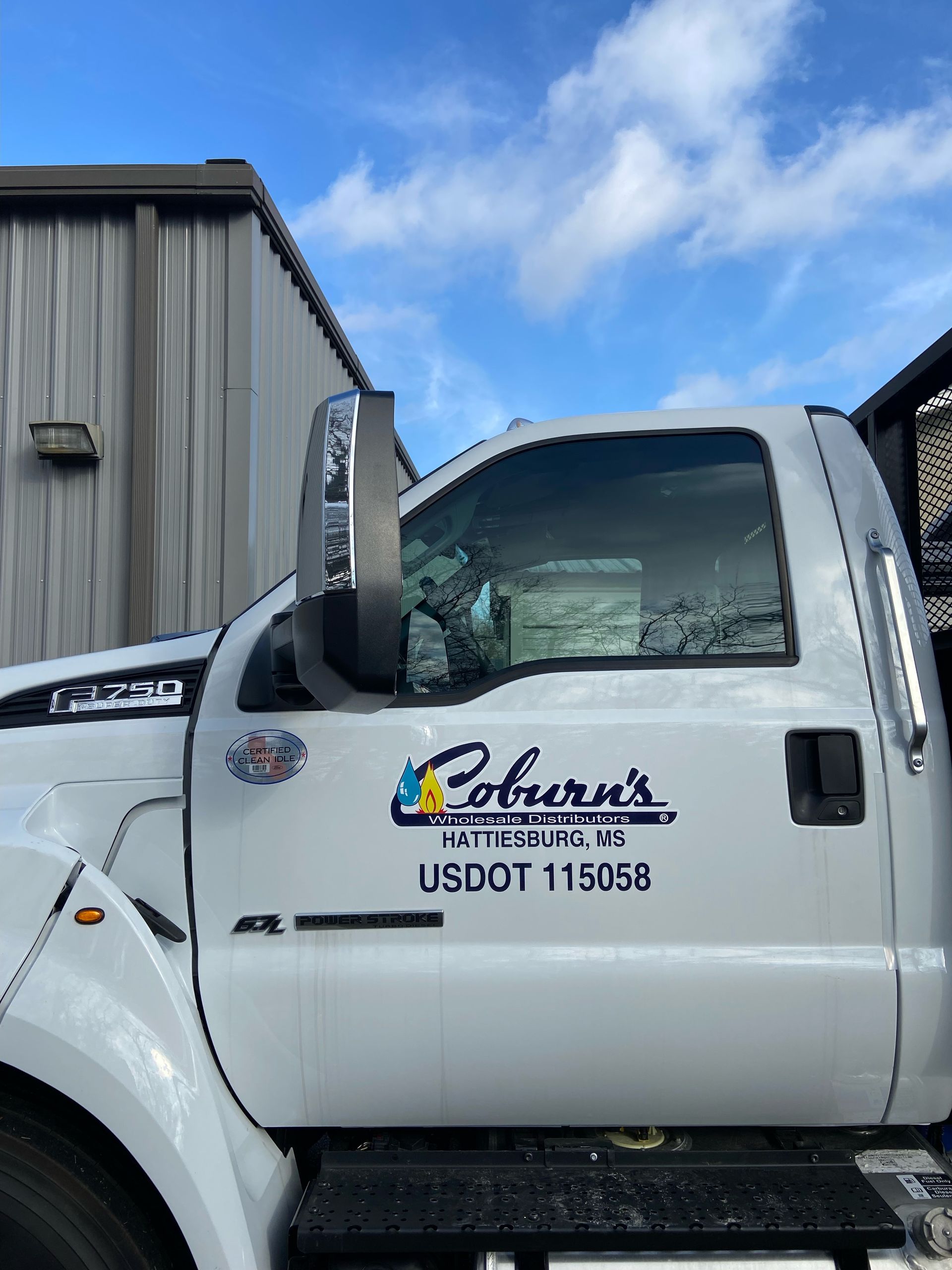 A white truck is parked in front of a building.